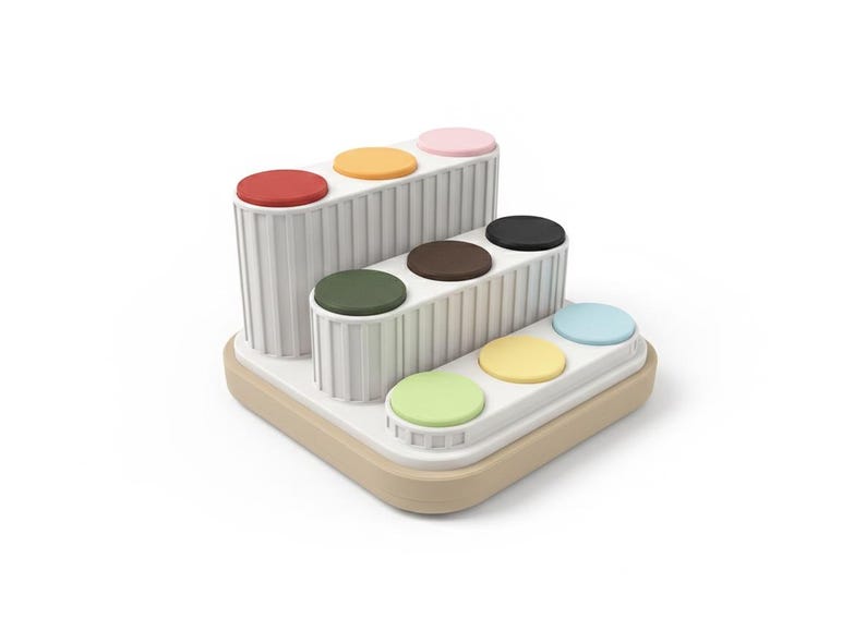 Puede incluir: Un juguete multinivel blanco y beige con acentos circulares coloridos. El juguete presenta c&iacute;rculos rojos, naranjas, rosas, negros, marrones, verdes, amarillos y azules. El juguete est&aacute; dise&ntilde;ado con una estructura escalonada.
