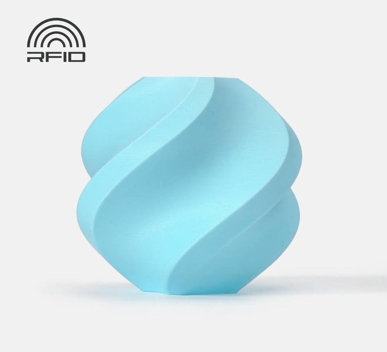 May include: A light blue, abstract, decorative object with a twisted, wave-like design. The object has a smooth surface and is set against a plain background. The top left corner features the text "RFID" above a stylized symbol.