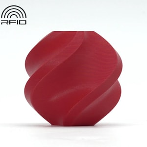 May include: A red, abstract sculpture with a twisted, symmetrical design. The object has a smooth, matte finish and is set against a white background. The sculpture's form is reminiscent of a stylized knot or a continuous ribbon.