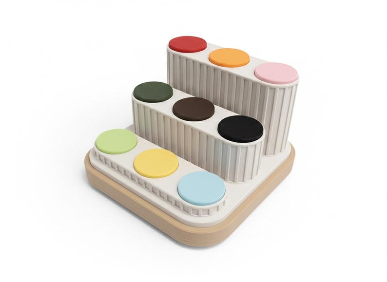 Puede incluir: Un organizador moderno de varios niveles con base de madera clara y soportes verticales blanquecinos. Cada nivel contiene cojines circulares de colores: rojo, naranja, rosa, verde, amarillo, azul, marr&oacute;n y negro. Dise&ntilde;o minimalista y funcional.