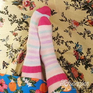 May include: A pair of colorful striped socks with pink heels and toes. The socks are made with a soft yarn and have a comfortable fit.