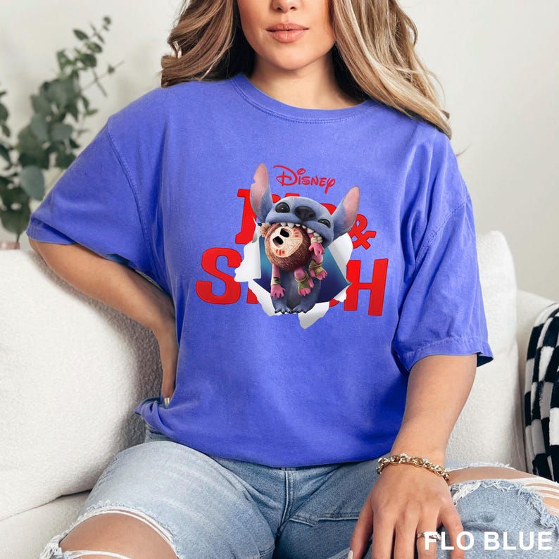 Puede incluir: Camiseta azul con un gr&aacute;fico de Stitch de Lilo & Stitch de Disney. El dise&ntilde;o muestra a Stitch saliendo de un efecto de papel rasgado, con el logo de Disney arriba. La camiseta es de color azul liso.