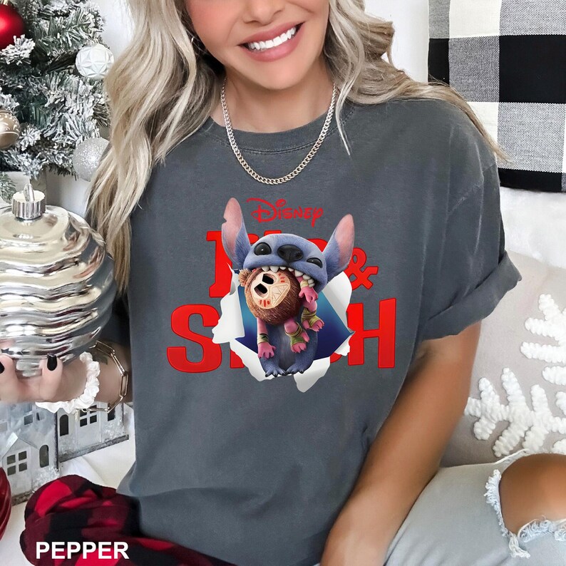Puede incluir: Camiseta gris oscuro con el personaje de Disney Stitch rompiendo un efecto de papel rasgado. La camiseta tiene las palabras "Lilo & Stitch" en rojo y el logotipo de Disney. La camiseta es de estilo casual y c&oacute;modo.