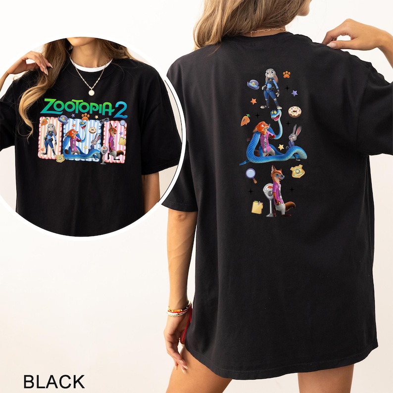 May include: Black t-shirt featuring the text "ZOOTOPIA 2" with cartoon characters on the front. The back of the shirt displays additional Zootopia characters and icons. The shirt is a casual, oversized fit.