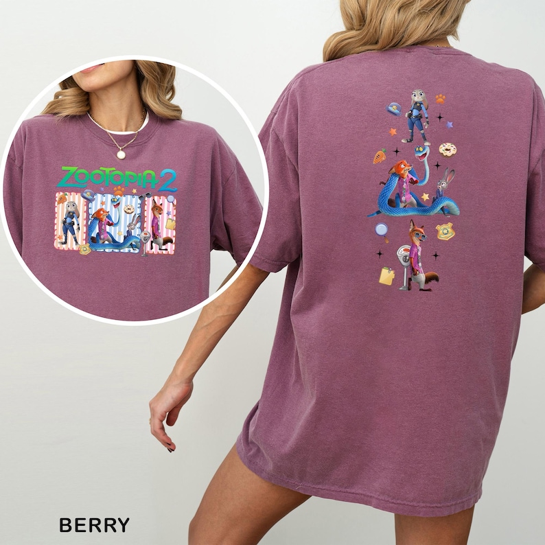 May include: Berry-colored t-shirt featuring a colorful graphic from the movie "Zootopia 2" on the front and back. The front graphic includes the movie title and characters. The back graphic showcases various characters and elements from the film.