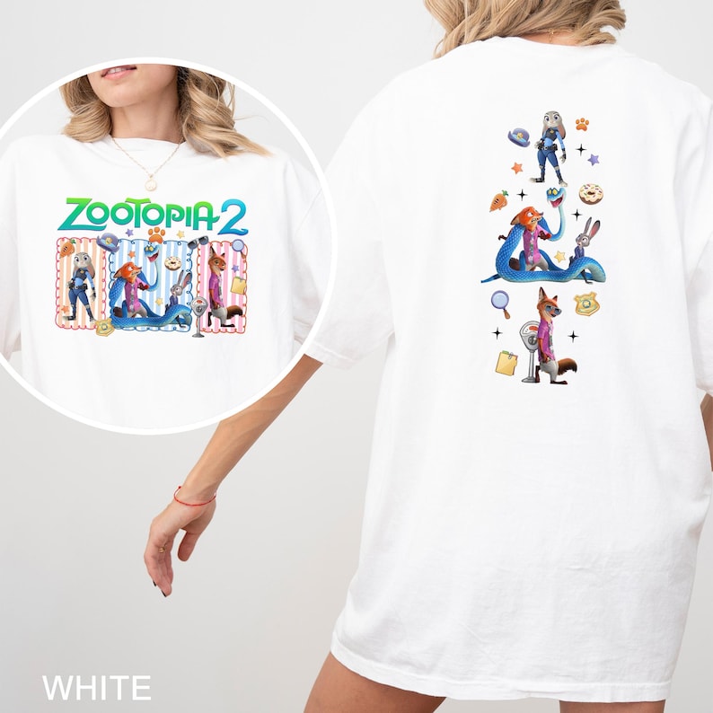 May include: White t-shirt featuring the text "Zootopia 2" in green and blue. The front graphic includes cartoon characters. The back of the shirt has additional character graphics. The shirt is made of a soft material.