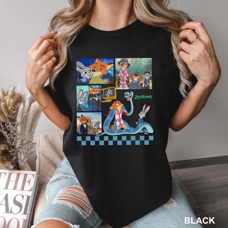Może przedstawiać: Czarna koszulka z kolorową grafiką postaci z filmu animowanego "Zwierzogr&oacute;d". Projekt zawiera wizerunki Judy Hopps, Nicka Wilde'a i innych postaci. Widoczne jest r&oacute;wnież słowo "Zwierzogr&oacute;d".
