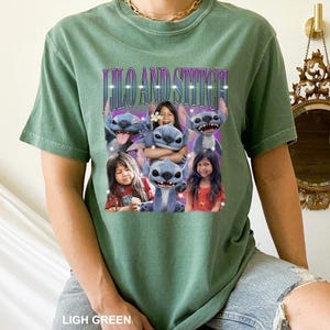 May include: Light green t-shirt featuring a graphic of Stitch from Lilo & Stitch with the text "Lilo and Stitch". The graphic includes images of Stitch and children. The shirt is made of a soft material.