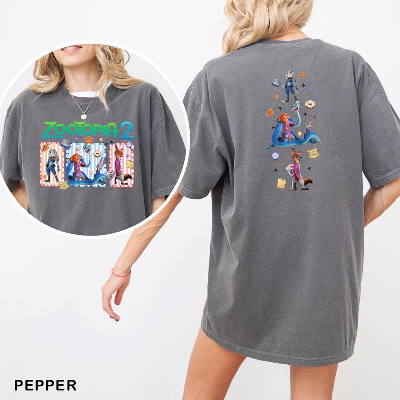 May include: Pepper-colored t-shirt featuring the text "Zootopia 2" with cartoon characters on the front. The back of the shirt displays a vertical graphic of characters and objects from the movie. The shirt has short sleeves and a relaxed fit.