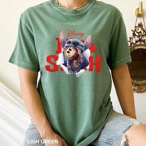 Puede incluir: Camiseta verde claro con un gr&aacute;fico de Stitch de Lilo & Stitch de Disney. El dise&ntilde;o incluye el logotipo de Disney y las palabras "Lilo & Stitch" en rojo. La camiseta es de color liso y tiene mangas cortas.