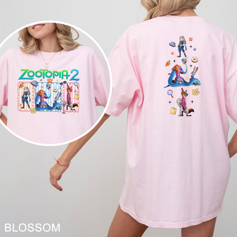May include: Light pink t-shirt featuring a colorful graphic from the movie "Zootopia 2". The front design includes the movie title and characters. The back of the shirt has additional character illustrations. The shirt is made of a soft material.
