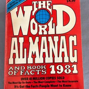 Puede incluir: Un libro de tapa dura rojo titulado "The World Almanac and Book of Facts 1981" con una ilustración de globo en la portada. El libro es el almanaque más vendido durante 113 años e incluye a los ganadores de los Juegos Olímpicos de 1980. Cuesta $4.50.
