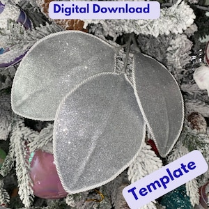 May include: Three silver glitter leaf ornaments with white rope trim. The leaves are attached to a stem and are displayed on a snow-covered Christmas tree. Text on the image reads "Digital Download" and "Template".