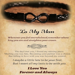 May include: A black leather bracelet with an infinity symbol charm. The charm is engraved with the names "John" and "Bex" and a heart symbol. The text "Lo My Man" and a romantic message are also visible.