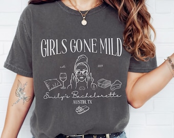 Puede incluir: Camiseta gris oscuro con el texto "GIRLS GONE MILD" y un dibujo lineal de una mujer con gafas de sol, una copa de vino y artículos de spa. También se incluye el texto "Emily's Bachelorette, Austin, TX".