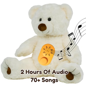May include: A white plush teddy bear with a brown nose and paw pads. An orange oval device with a speaker and a circular button is attached to the chest. Musical notes float to the right. Text reads: 2 Hours Of Audio, 70+ Songs.
