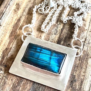 teal and blue mixture of colors in labradorite enveloped by sterling silver.