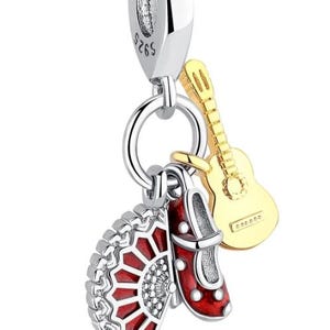 Puede incluir: Charm de plata con un abanico rojo y plateado, un zapato rojo y una guitarra dorada. El charm está diseñado para añadir a una pulsera o collar. El charm es un colgante con un lazo plateado en la parte superior.