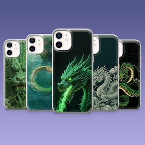 Könnte beinhalten: Eine Sammlung von fünf Handyhüllen mit Drachendesigns. Die Hüllen zeigen verschiedene Drachenillustrationen in Grün-, Weiß- und Goldtönen vor dunklen Hintergründen. Die Drachenkunst umfasst detaillierte Schuppen und Leuchteffekte.