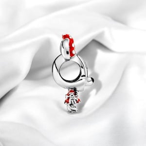Pu&ograve; includere: Ciondolo in argento con un design Mickey Mouse in smalto rosso e bianco. Il ciondolo presenta un anello rotondo per l'attacco a un braccialetto o una collana.