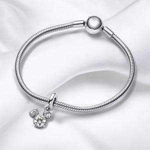 May include: A silver charm bracelet with a Mickey Mouse charm featuring clear cubic zirconia stones.