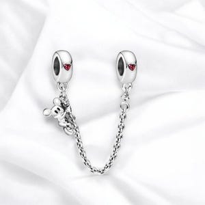 May include: Silver charm bracelet extender with a Mickey Mouse charm and two red heart charms.