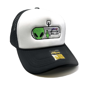 Puede incluir: Un gorro de camionero blanco y negro con un extraterrestre verde y un coche de policía en el espejo retrovisor. El gorro tiene una parte trasera de malla negra y una parte delantera blanca. El gorro tiene una etiqueta amarilla que dice "Producto con licencia oficial".