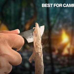 May include: A knife carving wood, with the text "BEST FOR CAMPING" in white. The knife has a dark blade and is cutting a piece of wood. The background is blurred, suggesting a camping scene.