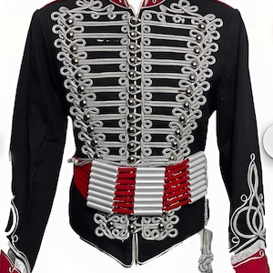 May include: Black military-style jacket with silver and white decorative trim. The jacket features a red collar and cuffs, a silver button closure, and a red and white belt. A tassel hangs from the waist.