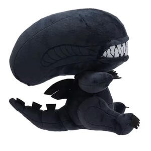 May include: A black plush toy of the Xenomorph from the Alien franchise. The toy is in a sitting position with its mouth open, revealing rows of sharp teeth. The toy has a long tail and a pair of small wings.