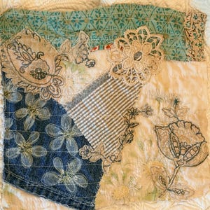 Peut inclure: Textile patchwork avec divers tissus, dont du denim, du tissu rayé et des motifs floraux. La pièce présente des détails floraux brodés et de la dentelle dans des tons neutres, avec une bordure à motifs turquoise. L'esthétique générale est vintage et artisanale.