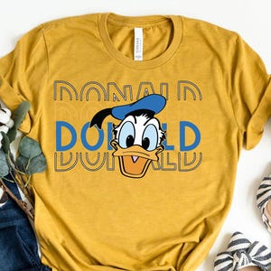 レトロなドナルドダックの顔のヴィンテージシャツ、クラシックなドナルドダックのシャツ、ディズニーキャラクターのTシャツ、ディズニーランドの休暇、ヴィンテージディズニーTシャツ、ドナルドTシャツ