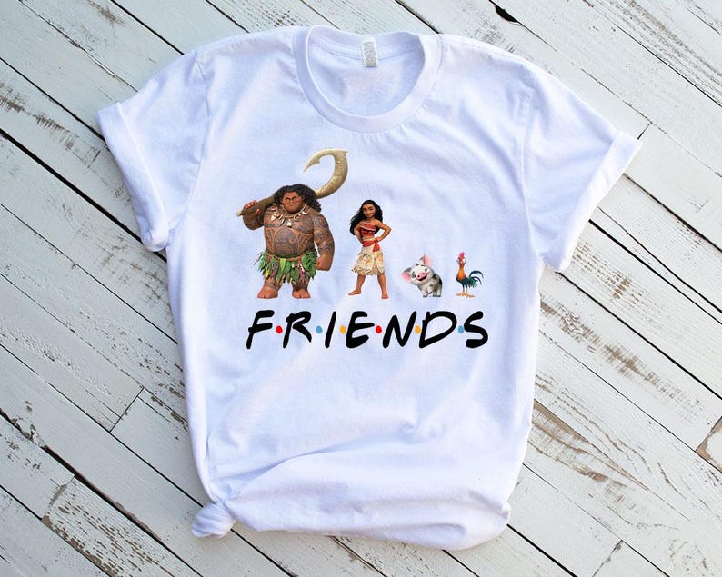 K&ouml;nnte beinhalten: Wei&szlig;es T-Shirt mit einem Grafikdruck von Figuren aus dem Animationsfilm Vaiana. Die Figuren sind Maui, Vaiana, Pua das Schwein und Hei Hei der Hahn. Der Text "FRIENDS" ist unter den Figuren gedruckt.