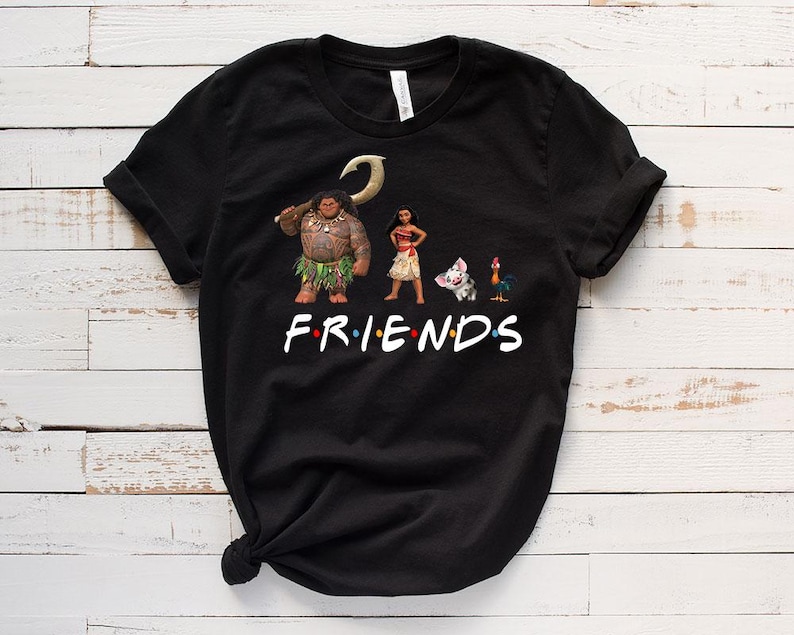 K&ouml;nnte beinhalten: Schwarzes T-Shirt mit einem Aufdruck von Figuren aus dem Film Vaiana. Die Figuren sind Maui, Vaiana, Pua das Schwein und Hei Hei der Hahn. Der Text "FRIENDS" ist unter den Figuren aufgedruckt.