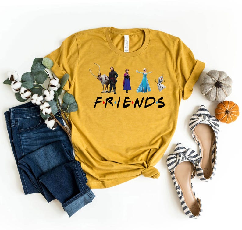 May include: A mustard yellow t-shirt with a graphic of characters from the movie Frozen. The text "FRIENDS" is printed below the graphic.