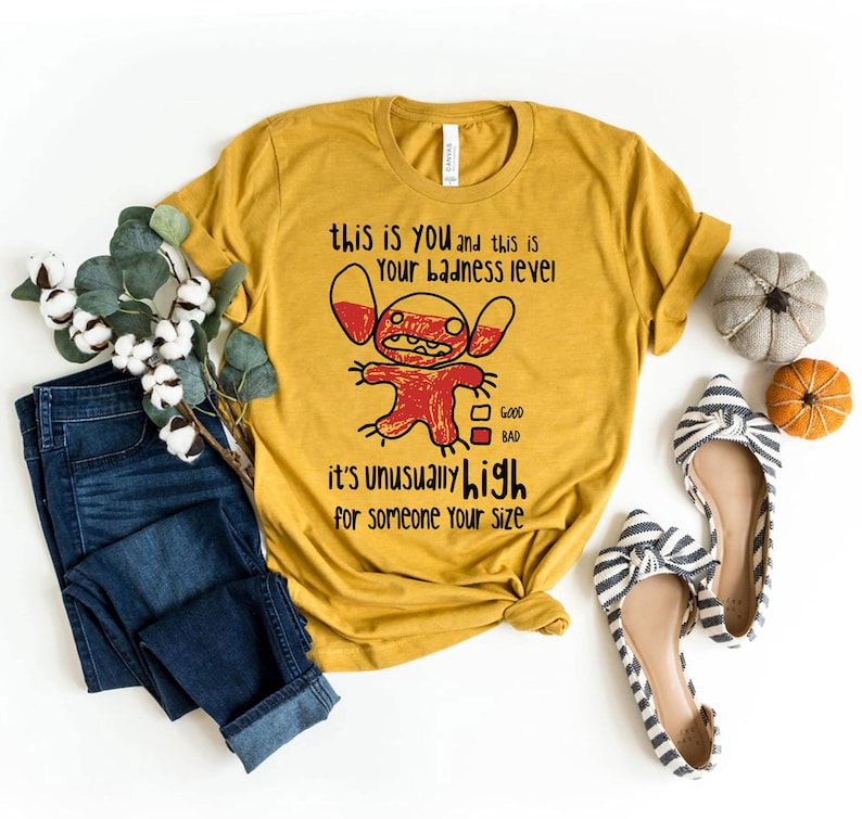May include: A yellow t-shirt with a cartoon character and the text "this is you and this is your badness level it's unusually high for someone your size". The character is red and has a scale with "good" and "bad" marked on it.