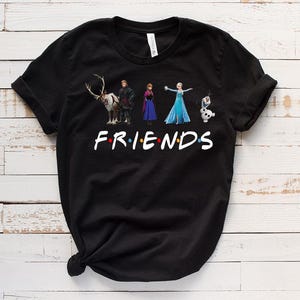 May include: Black t-shirt with a graphic of characters from the movie Frozen. The graphic includes Elsa, Anna, Kristoff, Sven the reindeer, and Olaf. The text "FRIENDS" is below the graphic.