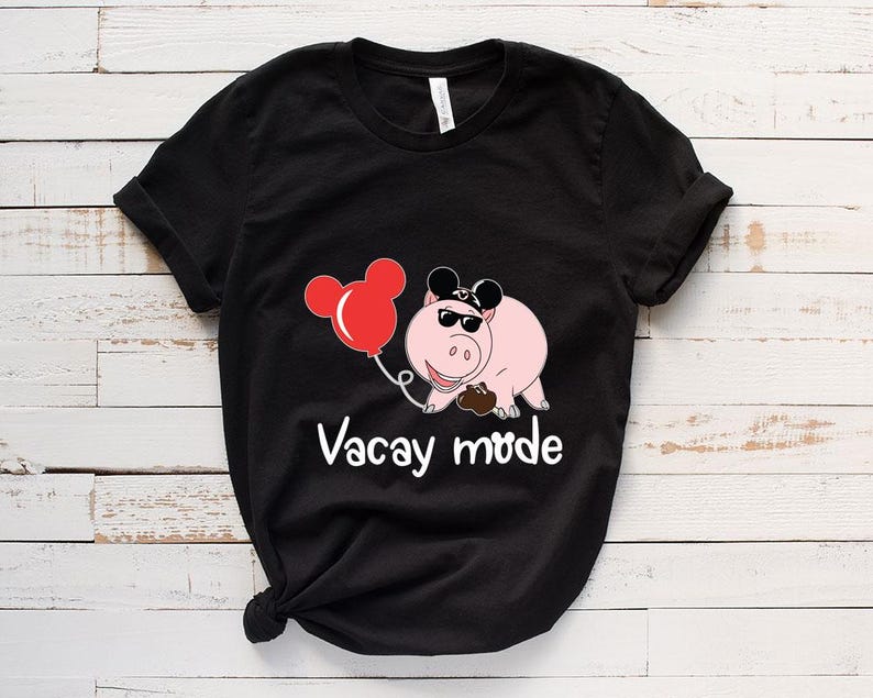 May include: Black t-shirt with a cartoon pig wearing sunglasses and a Mickey Mouse hat. The pig is holding a red balloon and the text "Vacay Mode" is printed below the pig.