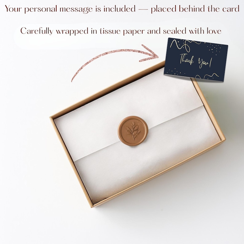 May include: A gift box with a white tissue paper interior, sealed with a brown wax seal featuring a leaf design. A navy blue card with gold text that reads "Thank You!" is placed behind the box. The box is wrapped with love.
