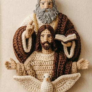 May include: A handcrafted crochet wall hanging depicting a religious scene. The artwork features three figures: an older man with a gray beard, a man with long brown hair, and a dove. The figures are in shades of brown, beige, and white, with a beige background.