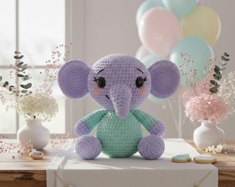 May include: A handmade crochet elephant in lavender and mint green. The elephant has large, round ears, a long trunk, and is sitting on a table with a banner that says "BABY JOY". Pastel balloons and flowers are in the background.