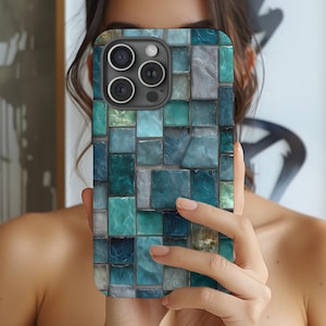 May include: A smartphone case with a mosaic tile design in shades of teal, blue, and gray. The case has a glossy finish and a camera cutout. The design is made up of small, square tiles, creating a textured appearance.