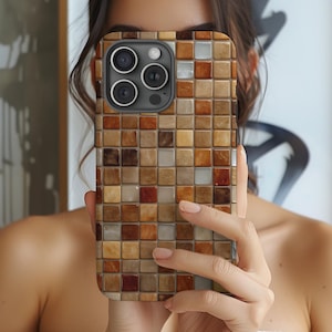 Può includere: Una custodia per telefono con un design a mosaico nei toni del marrone, beige e bianco. La custodia ha un motivo quadrato e copre la parte posteriore e i lati del telefono. Le lenti della fotocamera sono visibili.
