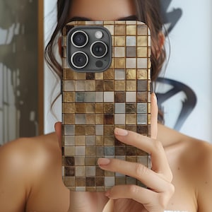May include: A mosaic-patterned phone case in shades of gold, brown, and white. The case features a grid-like design with small, square tiles. The phone case has a camera module with three lenses.