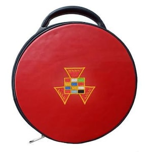 May include: A round, red carrying case with a black handle and trim. The case features an embroidered design in yellow, red, blue, and green. A zipper runs along the bottom edge.