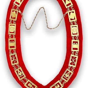May include: A red velvet collar with gold-colored metal links and pendants. The links are rectangular and feature various symbols. A gold chain connects the two ends of the collar. The collar is designed in an oval shape.