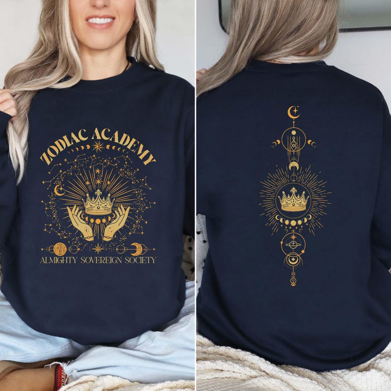 May include: Navy blue sweatshirt with a gold graphic design featuring a crown, stars, and the text "Zodiac Academy Almighty Sovereign Society". The back of the sweatshirt has a gold graphic design of a crown, stars, and moons.