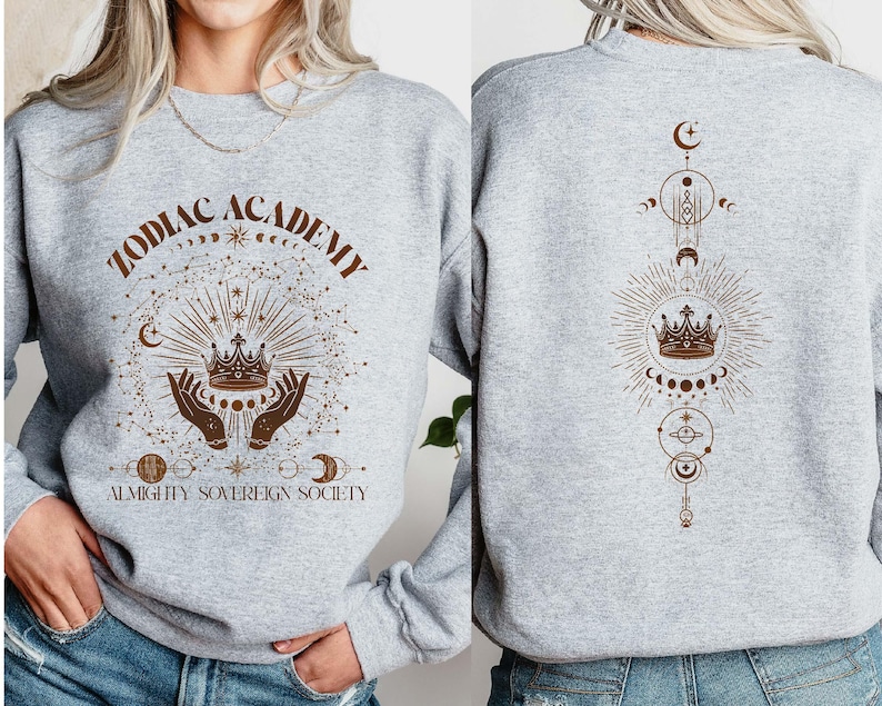 May include: Grey sweatshirt with a brown graphic design featuring a crown, stars, and the text "Zodiac Academy Almighty Sovereign Society".