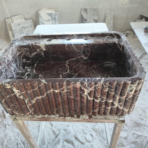 Lavandino in marmo naturale lavorato a mano con finitura lucida, perfetto per bagni eleganti. Design resistente e unico, realizzato in pietra pregiata.