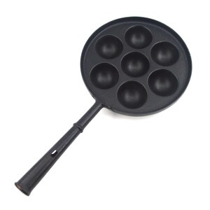 May include: Black cast iron takoyaki pan with seven round moulds. The pan has a long handle with a hole for hanging. Designed for cooking small, spherical Japanese snacks.